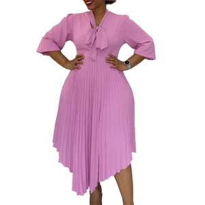 Detail of pussy-bow necktie and pleated texture on pink three-quarter sleeve dress