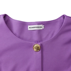 Detail of purple crew neck top with a relief gold metal button and branded inner label