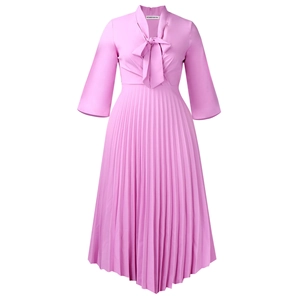 Detail of elegant pleated dress featuring a stylish bow tie neckline and 3/4 sleeves