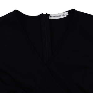 Detailed close-up of a black V-neck dress featuring a rear zipper and internal brand label
