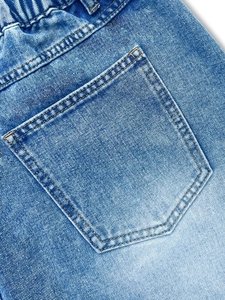 Détail de la taille élastique et poche arrière sur jupe en jean bleu clair à coutures oranges