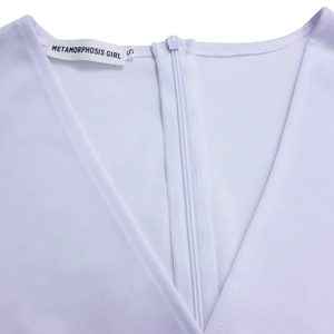 Detailaufnahme des verdeckten Reißverschlusses und Nackenetiketts am weißen Kleid
