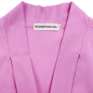 Detail of the elegant pink dress neckline featuring the Metamorphosis Girl brand label