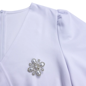 V-Ausschnitt mit Kristall-Perlen-Blumenbrosche und Plissee-Puffärmel am weißen Kleid