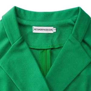 Detail eines eleganten hellgrünen Kleides mit Reverskragen, Rückenreißverschluss und Markenetikett