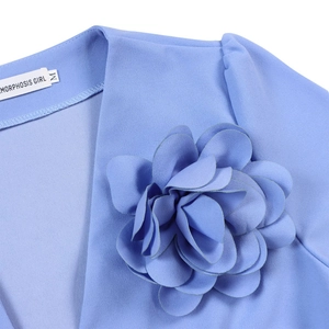 Detailed close-up of a large 3D floral appliqué on the V-neckline of a light blue dress