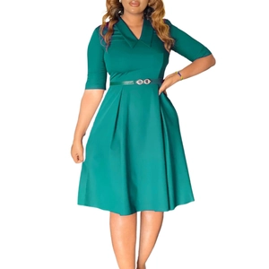 Detailed view of dark green pleated dress with lapel V-neck and golden buckle belt