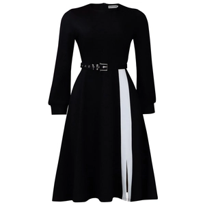 Detail of elegant black long-sleeve dress with white contrast slit and metallic belt buckle