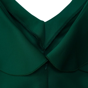 Detailed view of the V-neckline and invisible zipper on a dark green evening gown