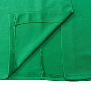 Detailaufnahme des smaragdgrünen Kleidsaums mit Rückenschlitz und sauberer Nahtverarbeitung