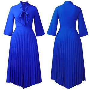 Detail of royal blue pleated dress featuring V-neckline with a bow tie and accordion folds