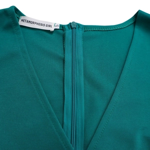 Detail des V-Ausschnitts und Reißverschlusses am dunkelgrünen, figurbetonten Kleid