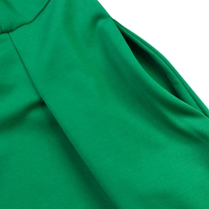 Detail view of the side pocket on a vibrant green V-neck A-line dress with smooth fabric