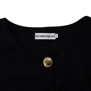 Detail of elegant black dress neckline with gold embossed button and brand label