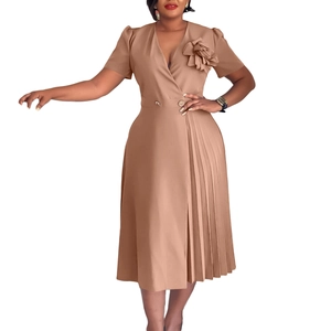 Detail of V-neck khaki dress with 3D floral accent and elegant pleated skirt design