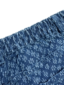 Detail view of high-waisted elastic denim waistband with textured jacquard starry pattern