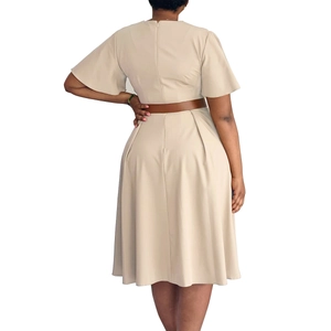 Detail view of the back of a beige V-neck dress featuring bell sleeves and a brown waist belt