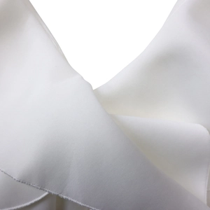 Close-up of premium white woven fabric texture and precise overlock stitching detail