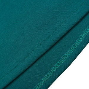 Dettaglio del tessuto a maglia verde scuro con cuciture piatte e sopraggitto di qualità