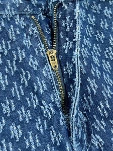 Macro detail of high-quality SBS metal zipper on textured blue starry denim pants