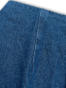 Macro shot of dark blue denim fabric texture and precise stitching on the skirt seam