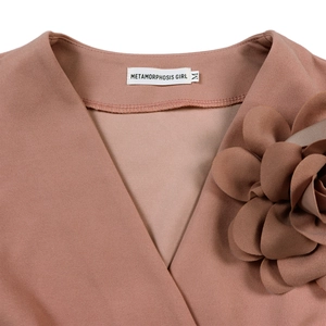 Detail of V-neck collar with brand label and elegant 3D flower applique on pink fabric
