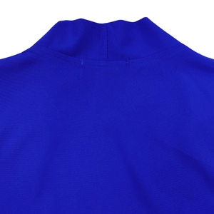 Macro detail of royal blue pleated fabric with mock neck design and ribbed texture