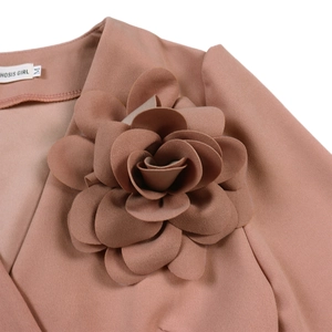 Macro detail of 3D fabric flower on V-neck dress with branded HOSIS GIRL label