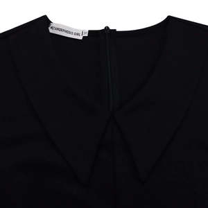 Dettaglio del colletto nero di un abito con revers Peter Pan e zip invisibile sul retro