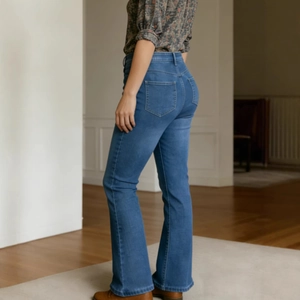 Detail shot of high waist flared jeans with metallic studs and vintage gradient wash