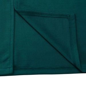 Detailed close-up of dark green knitted fabric with professional double-stitched hem and side slit