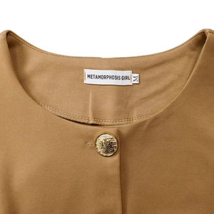 Detailed close-up of brown crew neck with elegant golden button and interior brand label