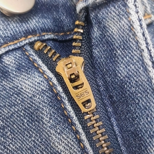 Vista macro dettagliata della patta in denim con cerniera in metallo SBS di qualità