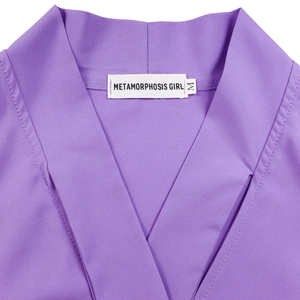 Close-up of elegant purple V-neck dress collar with size M label and quality stitching