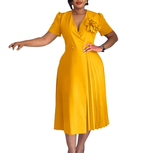 Detail of elegant ginger yellow midi dress with 3D shoulder flower and pleated hem