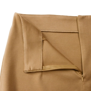 Macro shot of invisible zipper and fine stitching details on camel brown dress skirt waist