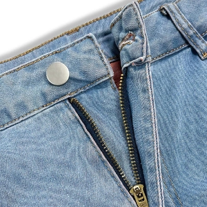 Detailaufnahme der Jeans-Textur mit SBS-Metallreißverschluss und silbernem Metallknopf