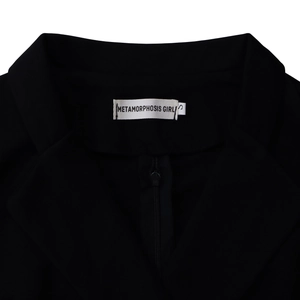 Detail von Reverskragen und Markenetikett auf schwarzem Langarm-Bodycon-Blazerkleid