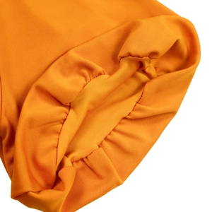 Detail eines hellorangen Strickkleids mit elastischem Laternenärmelbund und Stoffstruktur