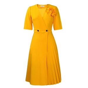 Detail view of mustard yellow V-neck dress with pleated hem and 3D floral ornament