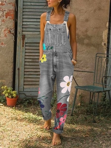 Detail view of grey denim overalls featuring colorful floral prints and adjustable straps