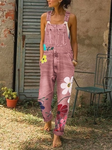 Detail of pink floral denim overalls featuring colorful daisy prints and large front pocket