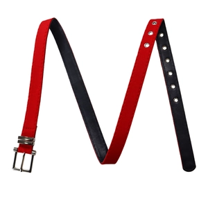 Detail of red fabric belt with black leather lining and silver metal pin buckle