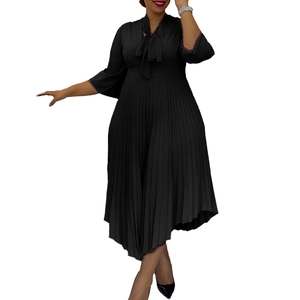Close-up of elegant black V-neck dress featuring a stylish bow-tie neckline and pleated hem