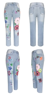 Detail of light blue straight jeans featuring colorful floral prints and ripped knee design