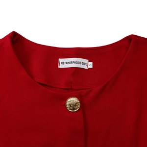 Detail of red women's top neckline with golden embossed button and size label