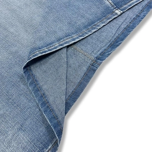 Close-up of premium light blue denim dress hem with durable double-stitch sewing detail