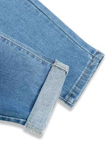 Gros plan de l'ourlet en jean avec coutures orange et texture de tissu sergé