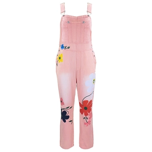 Detail of pink denim overalls with colorful floral prints and silver metal buckles