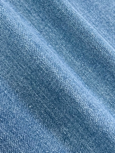 Vue macro montrant la texture du denim bleu clair et le motif de tissage sergé